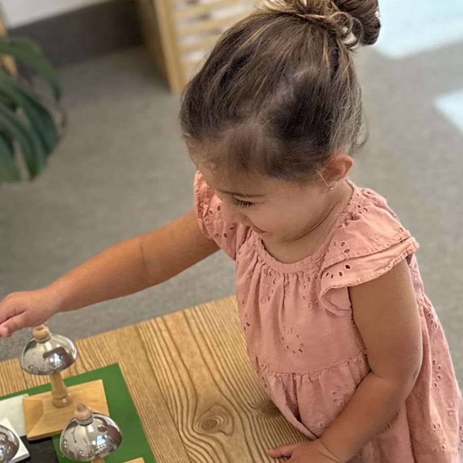 A Scripps Montessori child working independently with the sensorial bells